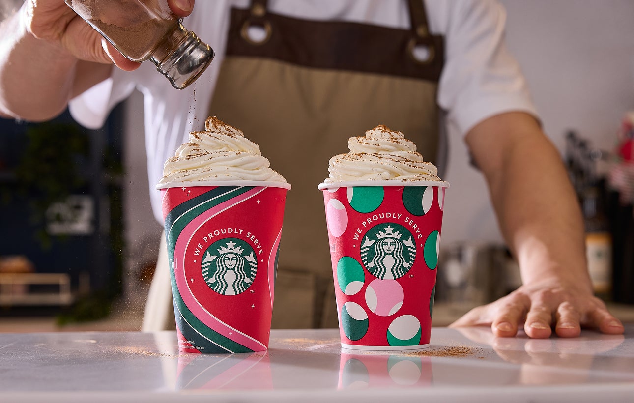 To Frappuccino® Blended Beverages i We Proudly Serve Starbucks-bægre, der passer til højtiden, med kanel drysset over den ene