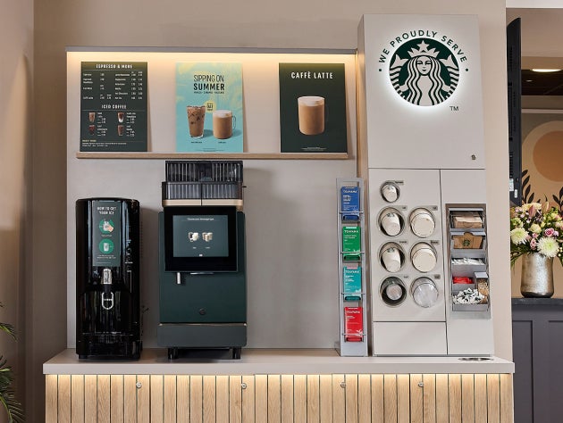 En We Proudly Serve Starbucks-kaffeautomat med selvbetjening