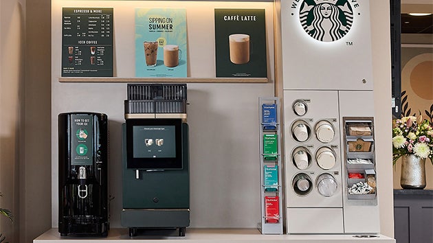 En We Proudly Serve Starbucks-kaffeautomat med selvbetjening